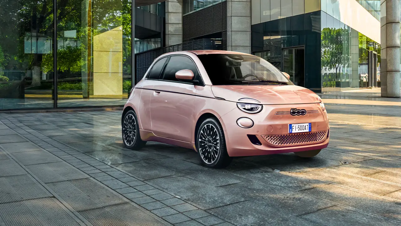 Fiat 500 elettrica colore rosa in un paesaggio moderno