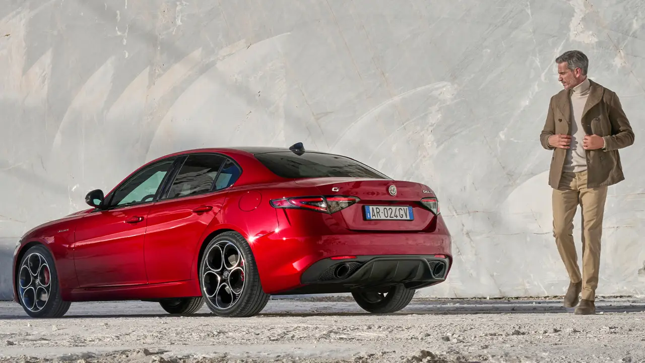 Alfa Romeo Giulia rossa con un uomo di fianco