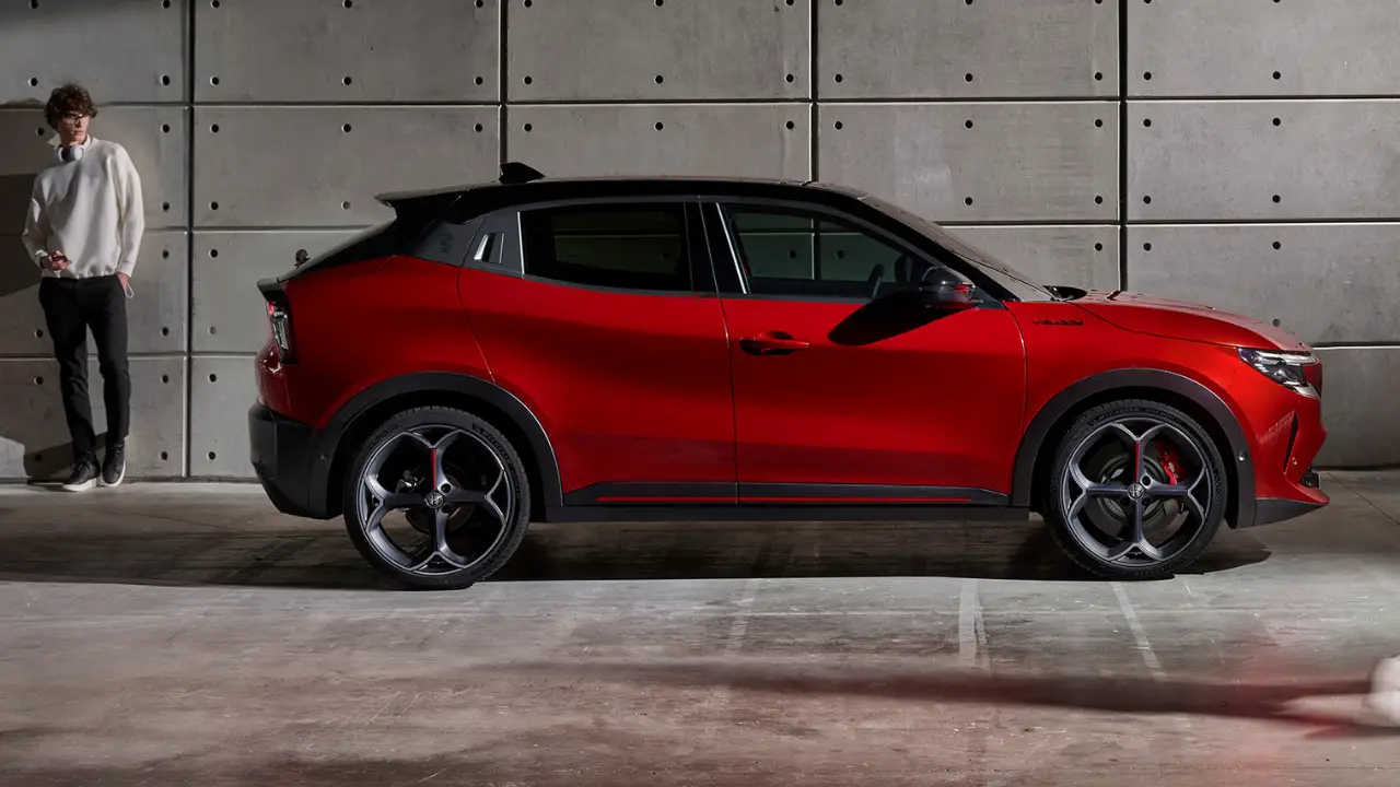Alfa Romeo Junior rossa parcheggiata con un uomo di fianco
